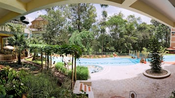 Una piscina al aire libre, sombrillas, sillones reclinables de piscina