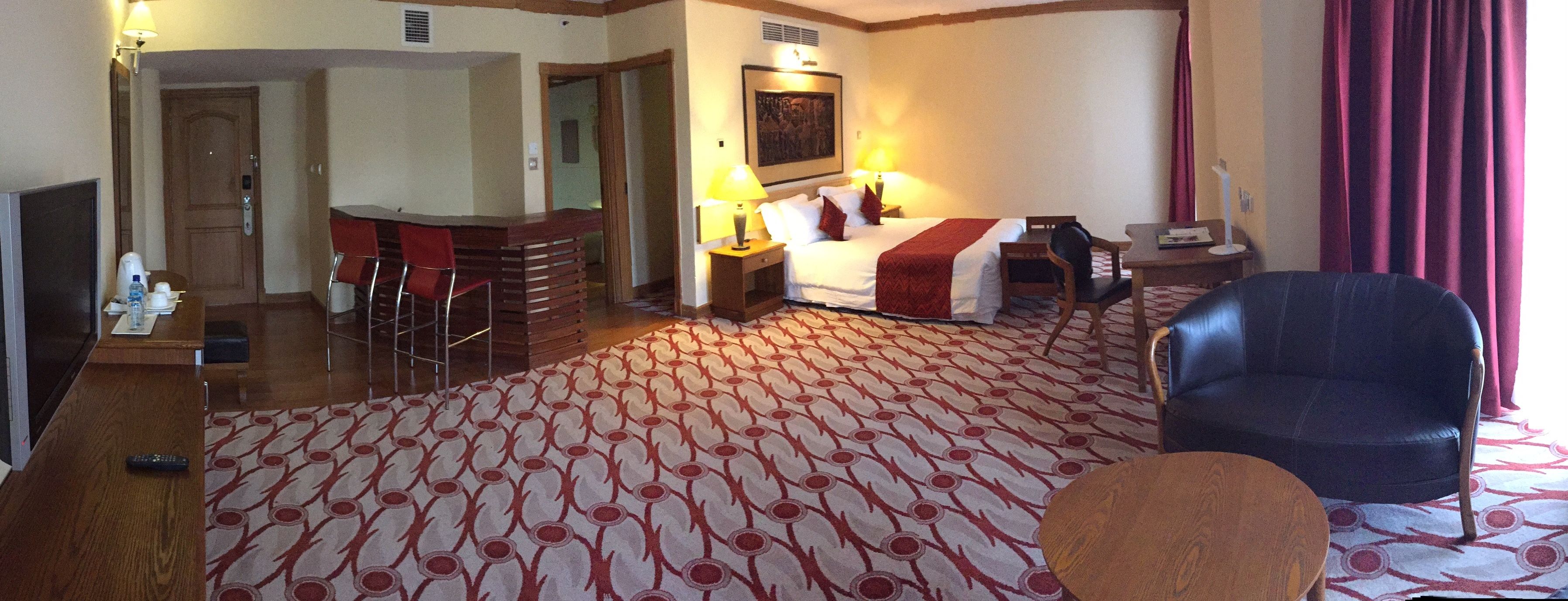Una habitación de hotel con una cama, un escritorio, una silla y un televisor.