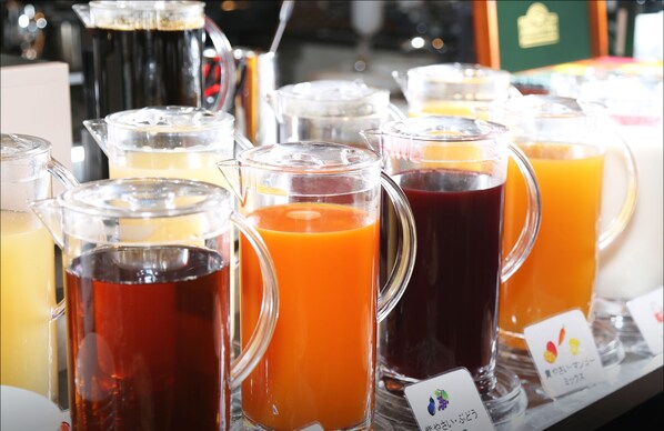 Variedad de bebidas en jarras de vidrio, algunas con etiquetas que indican los diferentes sabores.