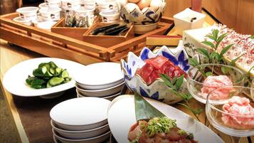 A variety of dishes and utensils on a table, including plates, bowls, and a tray with cups and chopsticks.