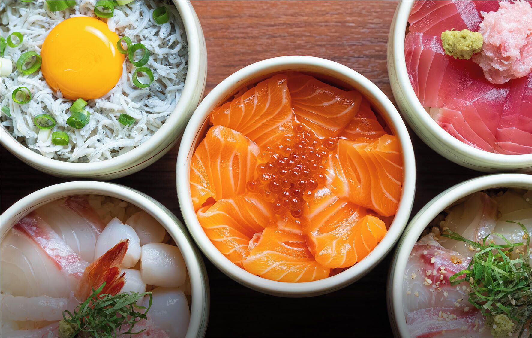 A variety of sashimi dishes in bowls.
