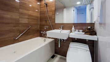 Ein modernes Badezimmer mit Badewanne, Toilette und Waschtisch.