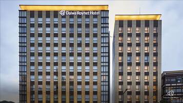 Two high-rise buildings with a modern architectural design, featuring a grid of windows and a prominent hotel sign.
