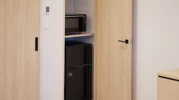 A compact kitchen with a microwave and a black refrigerator.