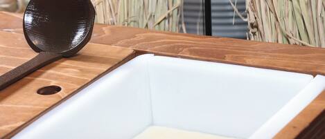 A wooden sink with a black faucet and a white basin.