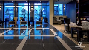 A modern hotel lobby with a checkered floor, seating areas, and large windows offering city views. - Daiwa Roynet Hotel Matsuyama (Matsuyama)