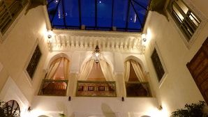 An interior view of a building with a glass ceiling, arched doorways, and decorative lighting. - Riad Palacio de las Especias (Marrakech)