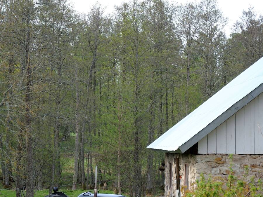 A rural barn with a stone exterior and a metal roof.