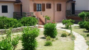 A two-story house with a stone staircase leading to the entrance.