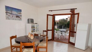 A dining area with a round table, chairs, and a cabinet with glass doors. - AbitaSardegna San Teodoro (San Teodoro)