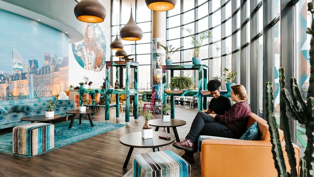 Een moderne zithoek met meubels, tafels en hanglampen.