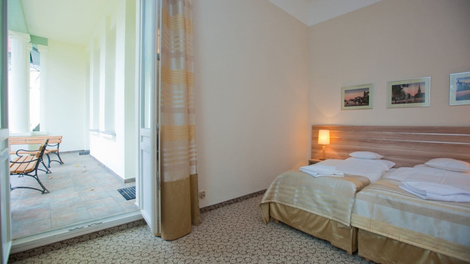 Une chambre d’hôtel avec un lit, un banc à l’extérieur et une vue sur l’extérieur.