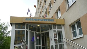 La entrada a Jugendherberge con puerta de vidrio, escalones y un cartel sobre la puerta.