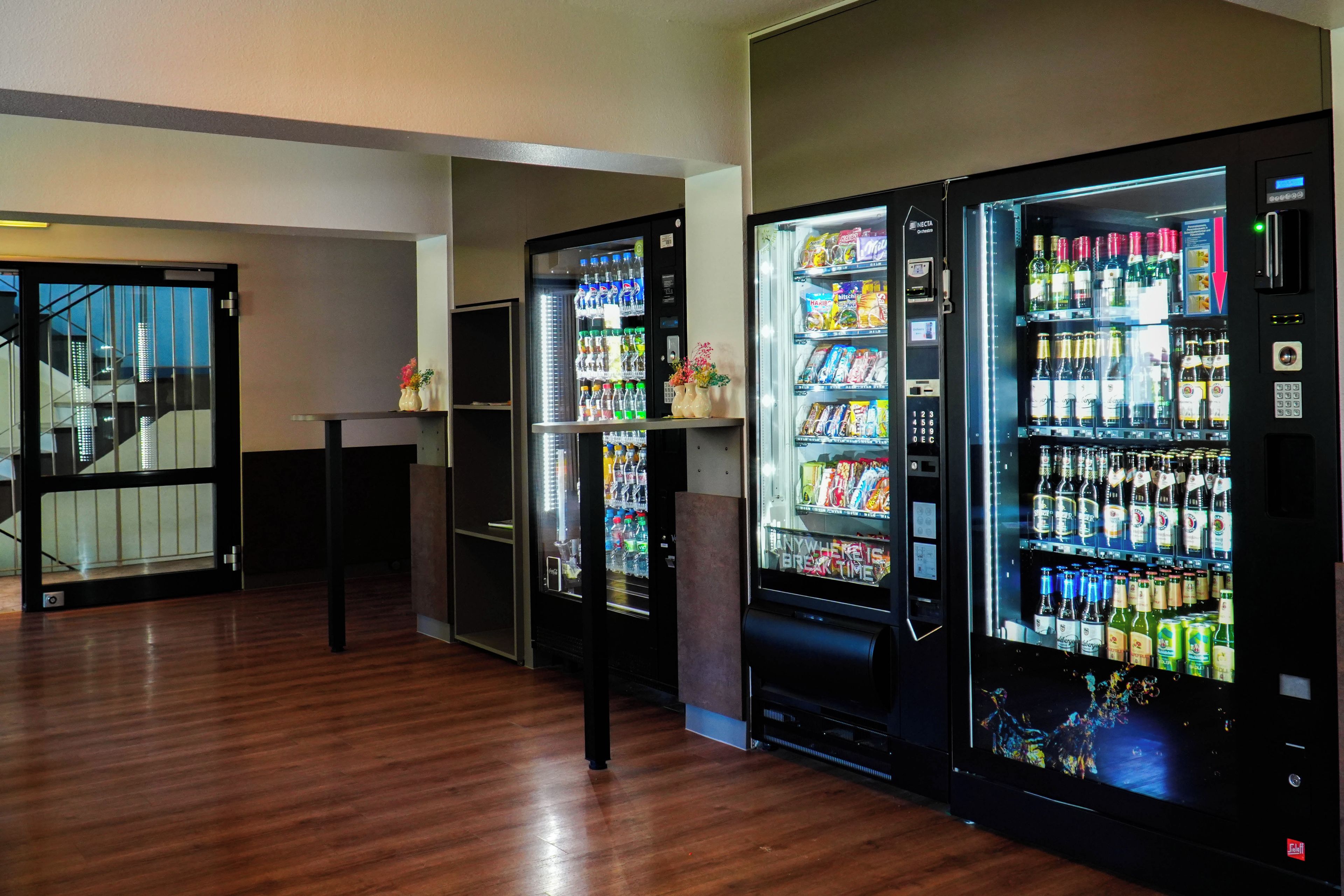 A row of vending machines with various beverages and snacks.