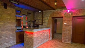 A kitchen area with a stone counter, wooden cabinets, and a tiled floor.