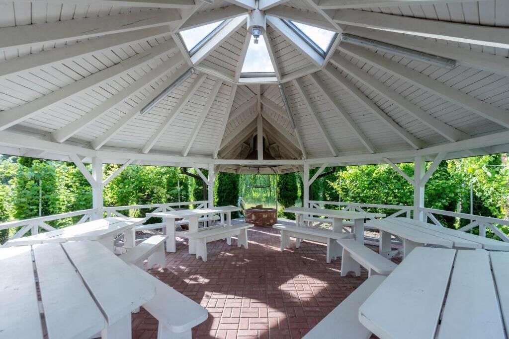 A gazebo with a white roof and multiple benches.