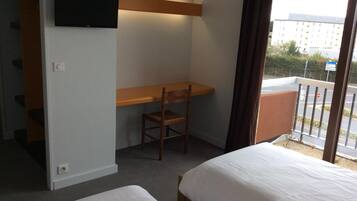 Ein Hotelzimmer mit Schreibtisch, Stuhl und zwei Betten.