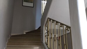 Una escalera con barandilla y un cuadro en la pared.