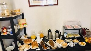 Un bufé de desayuno con diversos alimentos, bebidas y salsas.