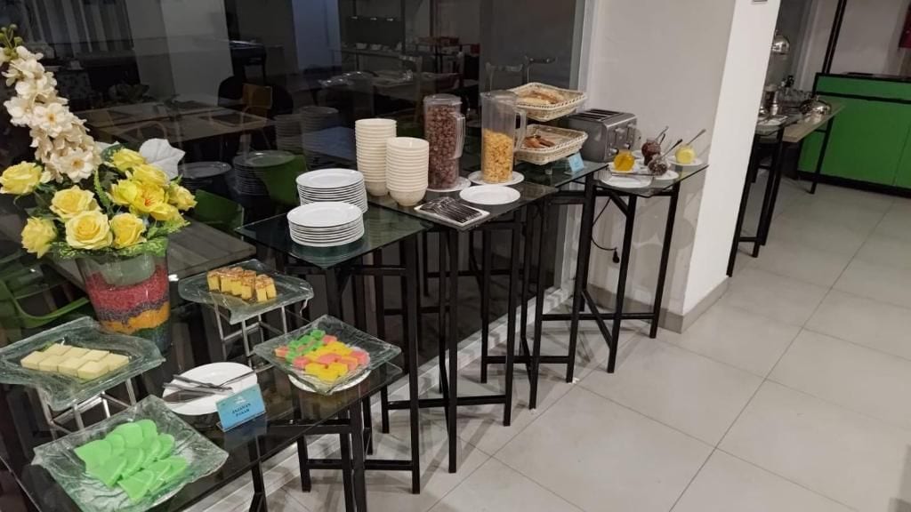 Montaje de bufé con diversos alimentos y un jarrón con flores.