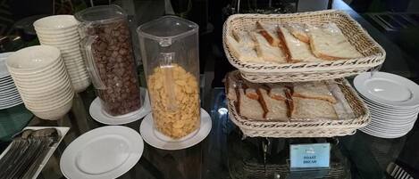 A buffet setup with various food items and serving utensils.