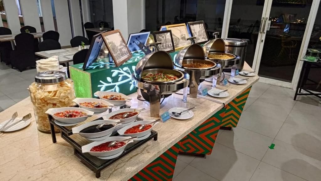 Disposição de buffet com diversos alimentos e utensílios.