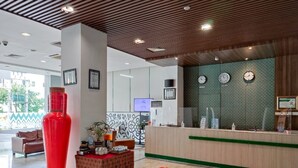 A modern reception area with a wooden ceiling, a reception desk, and a large red vase. - Khas Makassar  (Makassar)