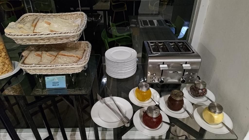 A breakfast buffet setup with bread, toast, and various condiments.
