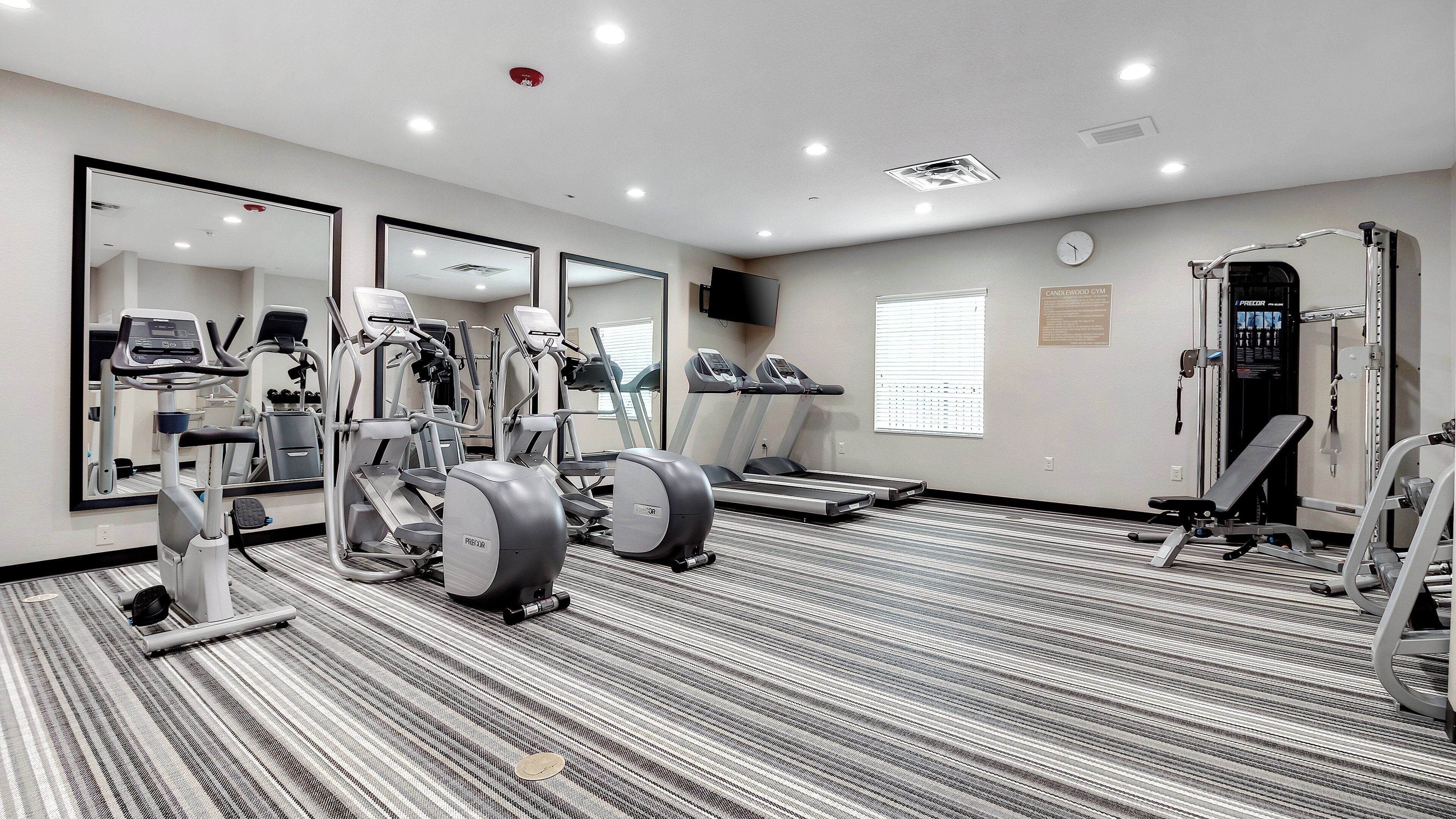 A gym with treadmills, elliptical machines, and weight equipment.
