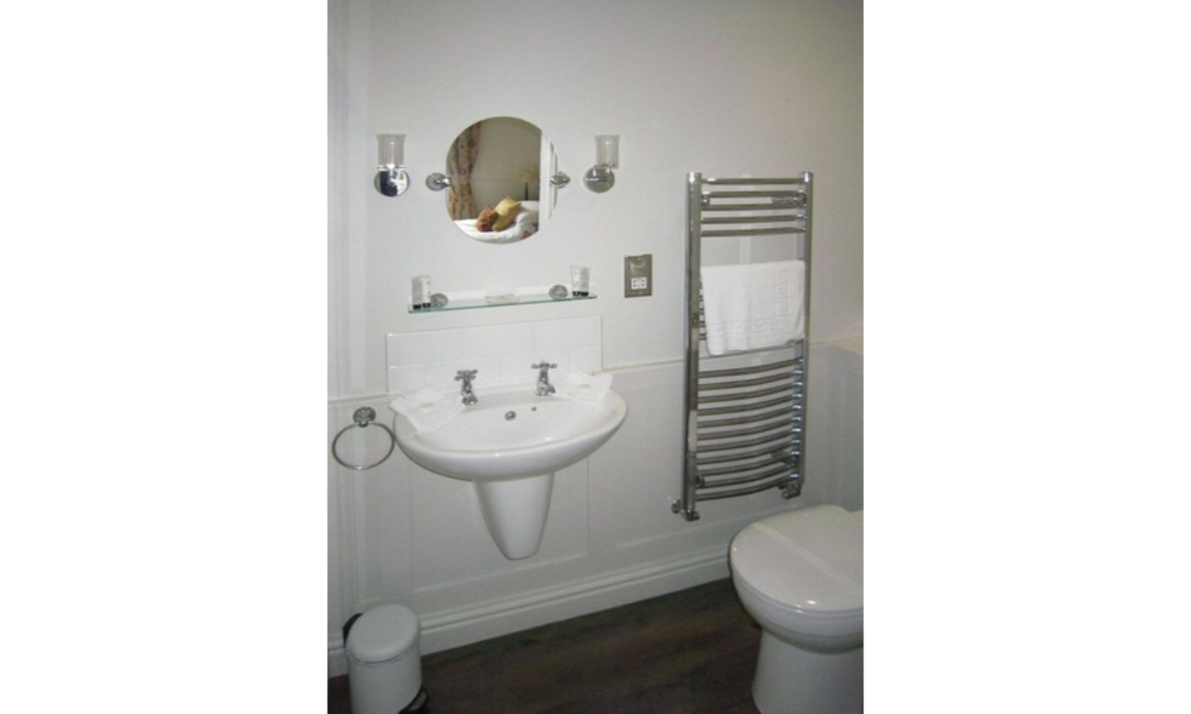 Ein Badezimmer mit Waschbecken, Spiegel und Handtuchhalter.