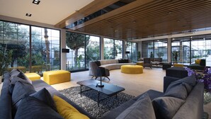 A spacious living area with large windows, a wooden ceiling, and modern furniture.