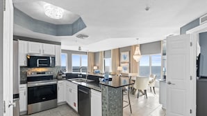 Una cocina moderna con electrodomésticos de acero inoxidable, una isla grande y vistas al exterior.