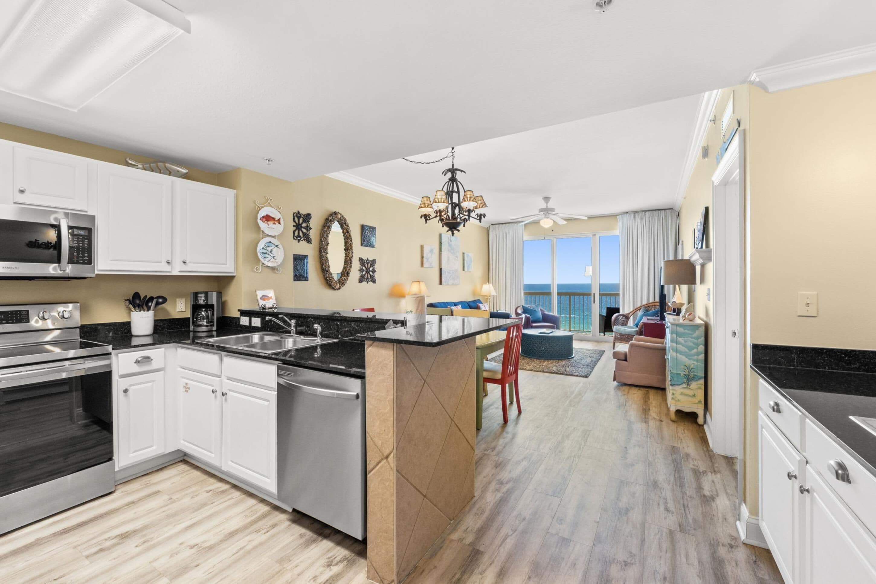 A modern kitchen with white cabinets, a stainless steel range, and a large island.