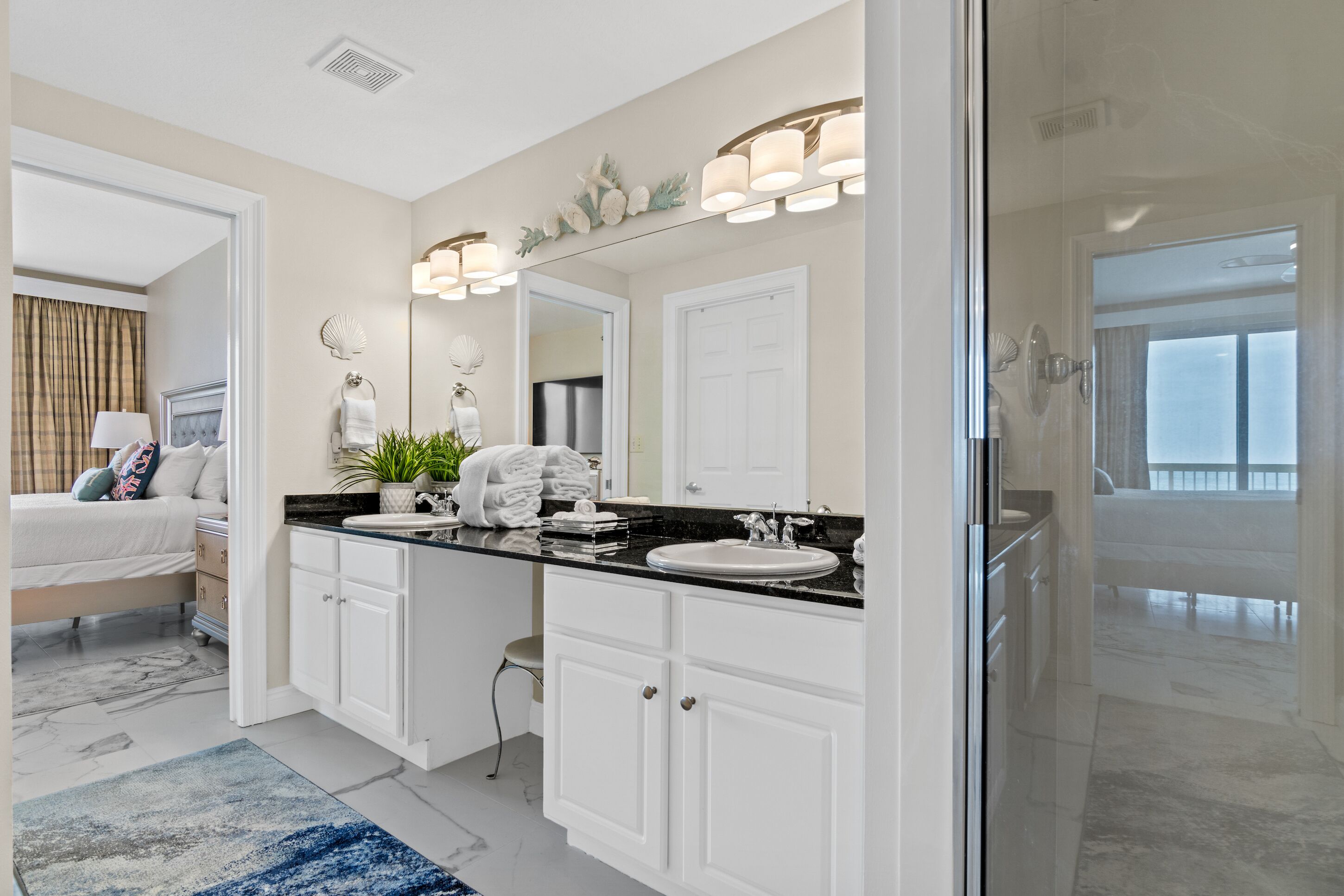 A modern bathroom with two sinks, a large mirror, and a shower area.
