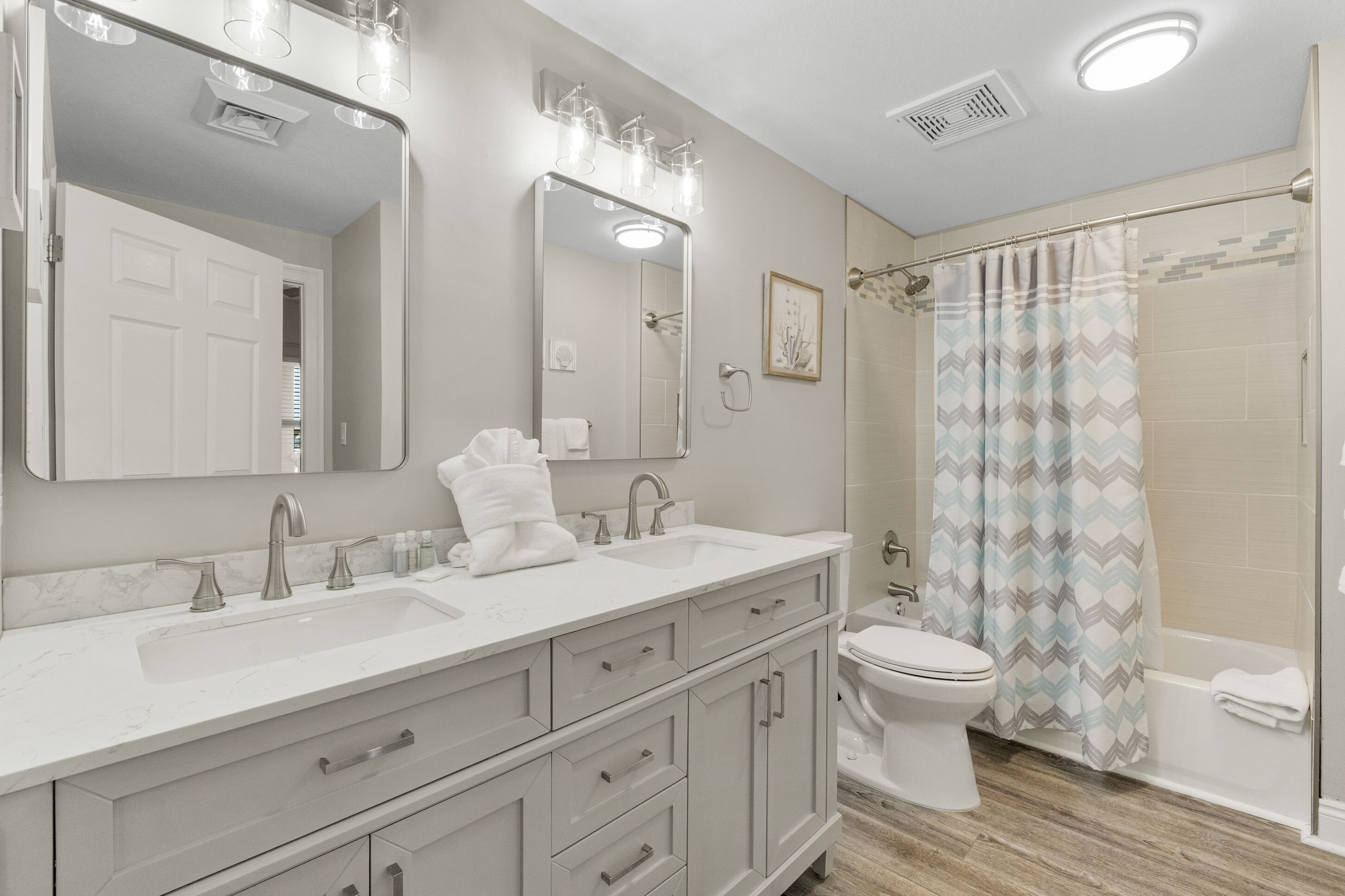 Un baño moderno con tocador, lavamanos y espejo.