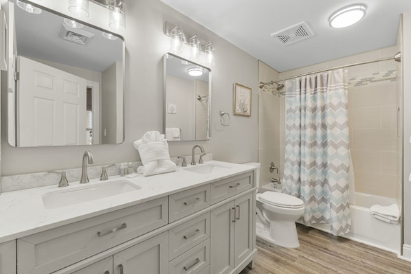 Un baño moderno con tocador, lavamanos y espejo.