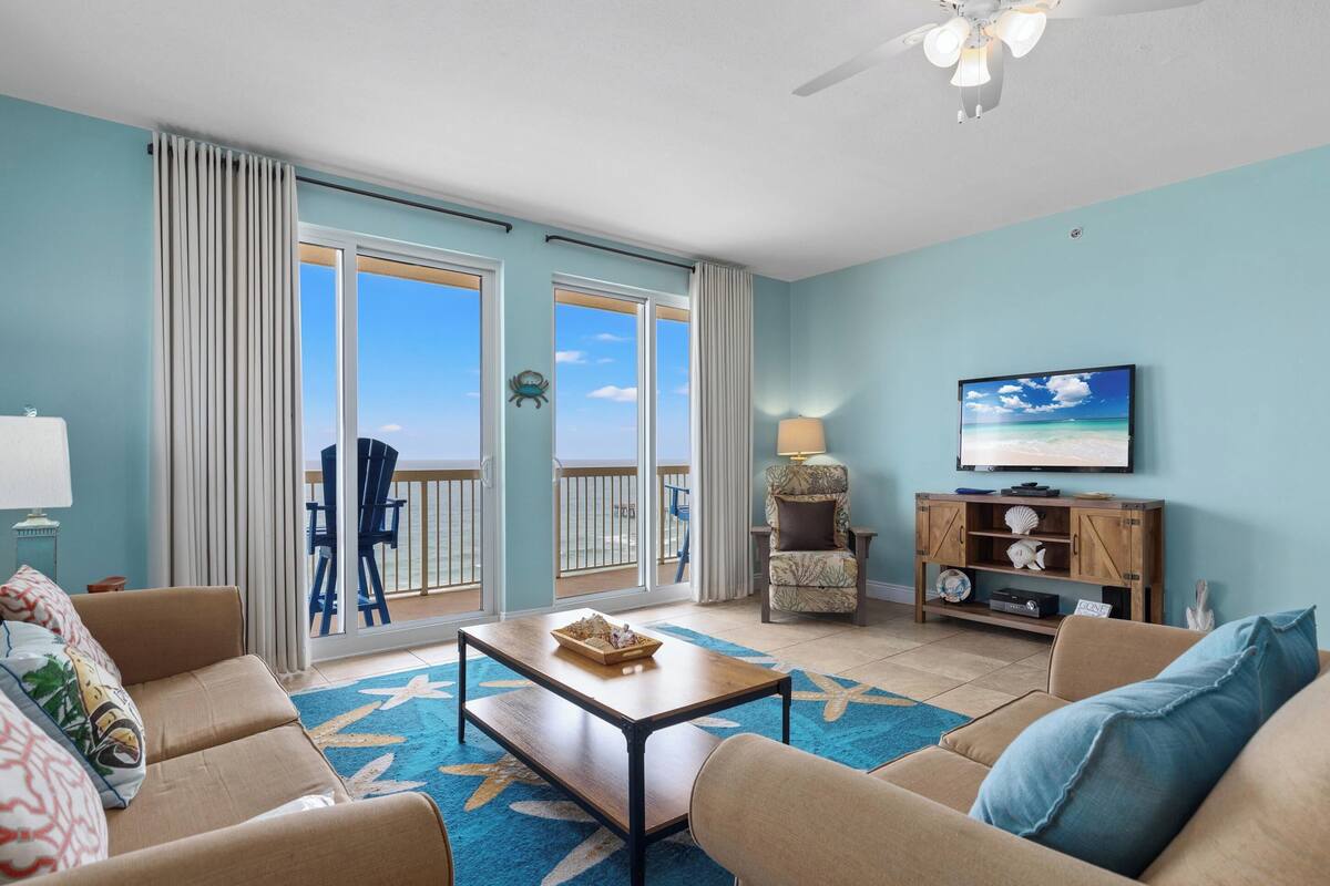 A living room with a sofa, coffee table, and a television.