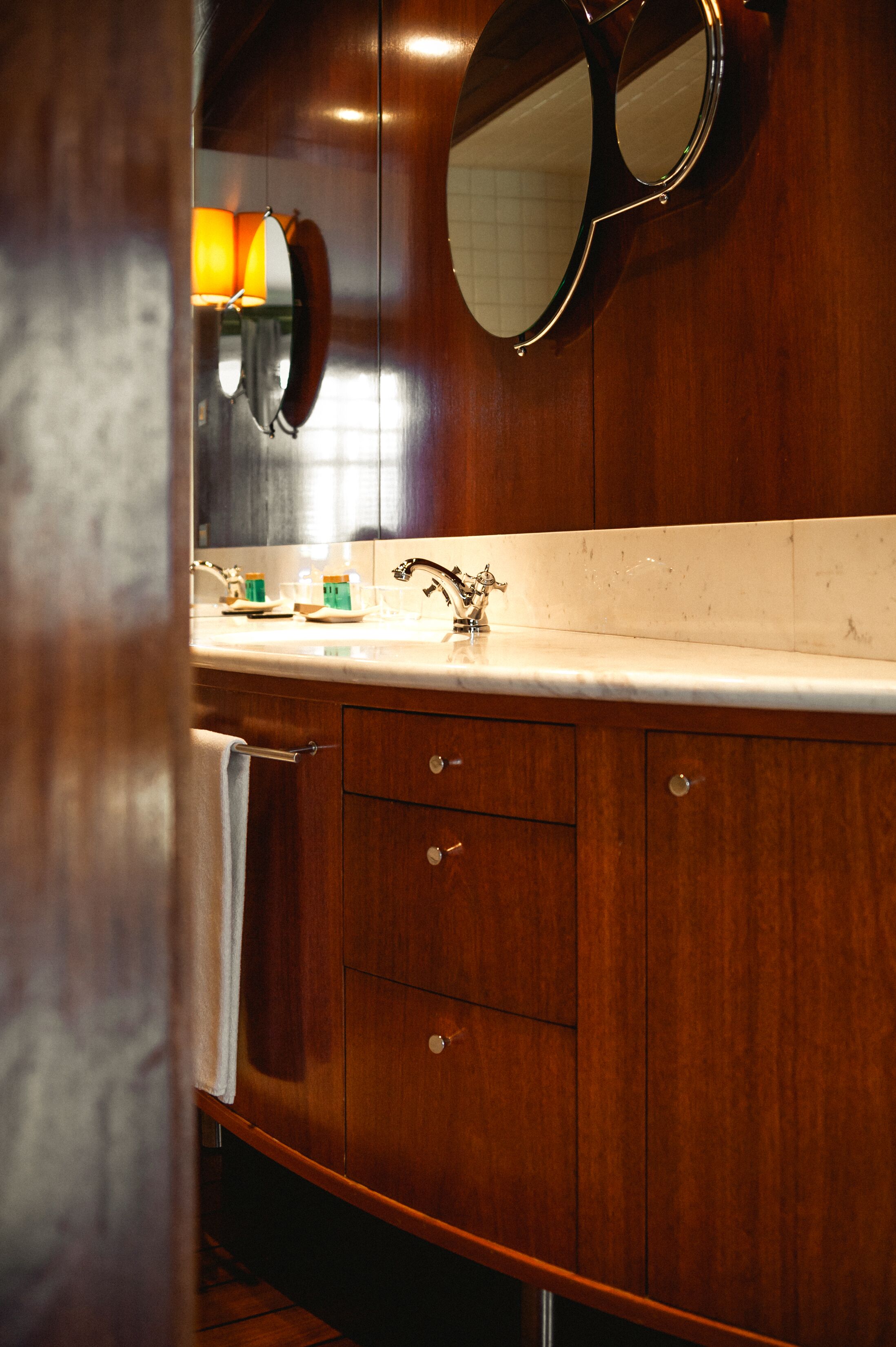 A wooden bathroom with a sink, mirror, and towel rack.