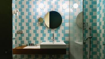 Une salle de bain avec un lavabo, un miroir et une douche.