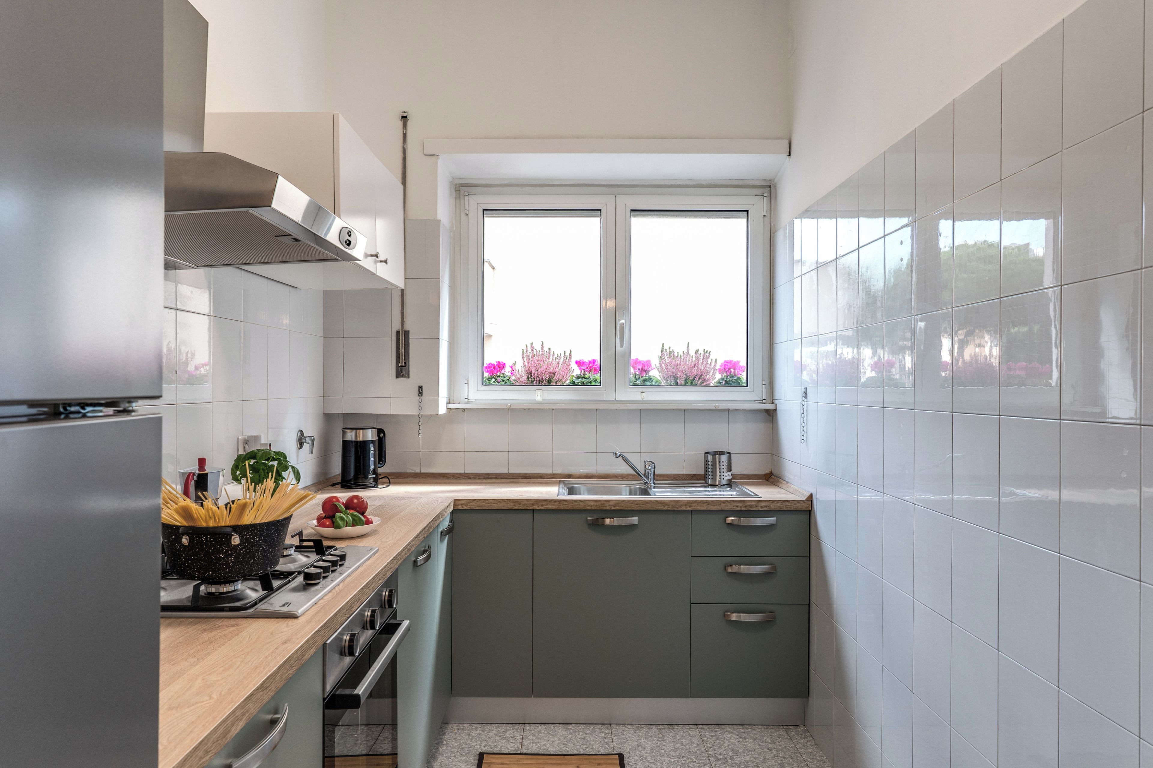 A compact kitchen with a window, a stove, and a sink.