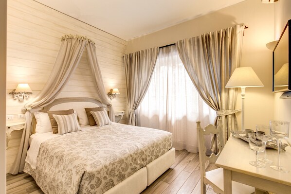 Un dormitorio con una cama grande, dos mesitas de noche con lámparas, una silla y una mesa con vasos.