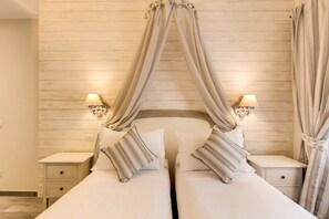 Cama doble con dosel, lámparas de noche y cabecera de madera.