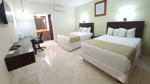 Habitación de hotel con dos camas, un escritorio, una silla, un teléfono y un espejo.
