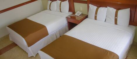 Dos camas individuales con cabeceras de madera, ropa de cama blanca y colchas marrones.