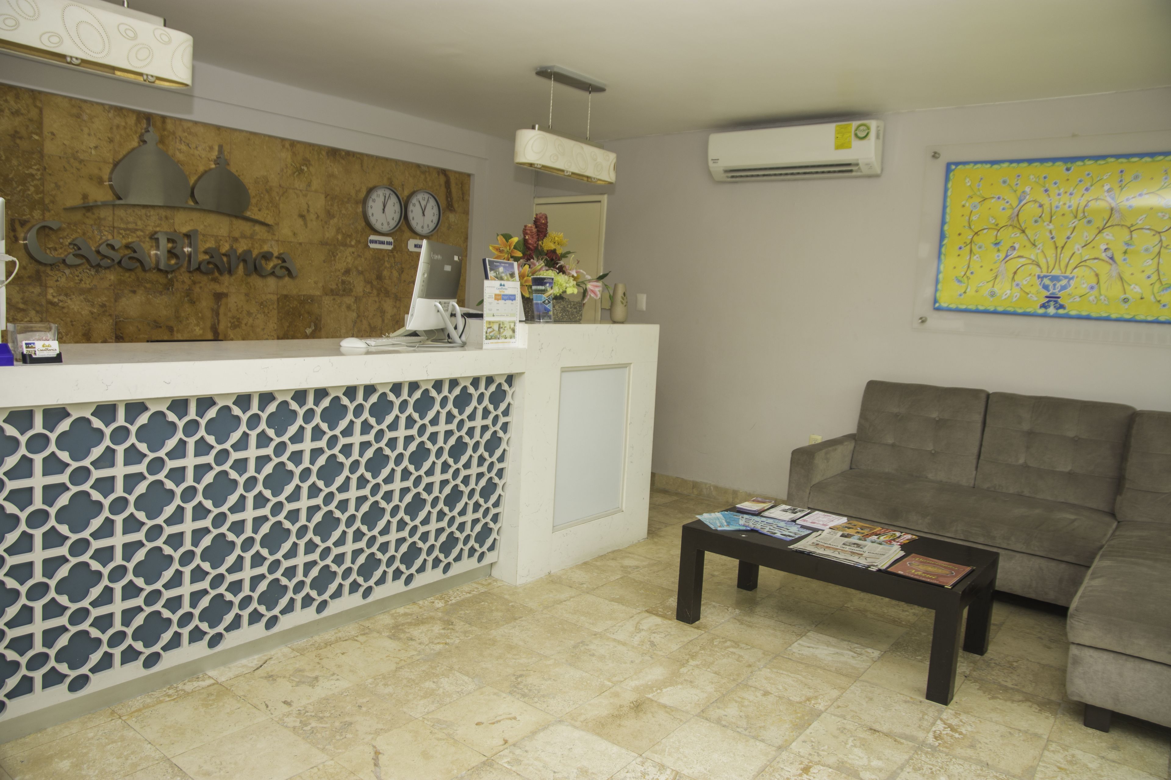 A reception area with a reception desk, a clock, and a sofa.
