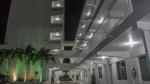 Un hotel de varios pisos con un atrio central, balcones y una fuente de agua.