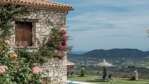 A stone building with a pool and a view of the countryside. - Agrikia Villa (Zakynthos)