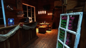 A cozy coffee shop interior with a wooden counter, a chalkboard menu, and a clock on the wall. - Hotel Bosque Verde Lodge (Sierra)