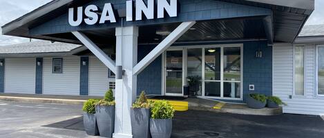Et USA Inn-bygning med en mørk facade, store vinduer og et skilt over indgangen.