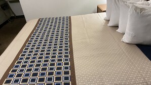A bed with a patterned bedspread and pillows.